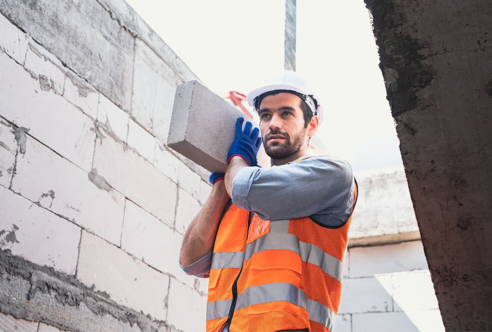 Construction worker carrying equipment